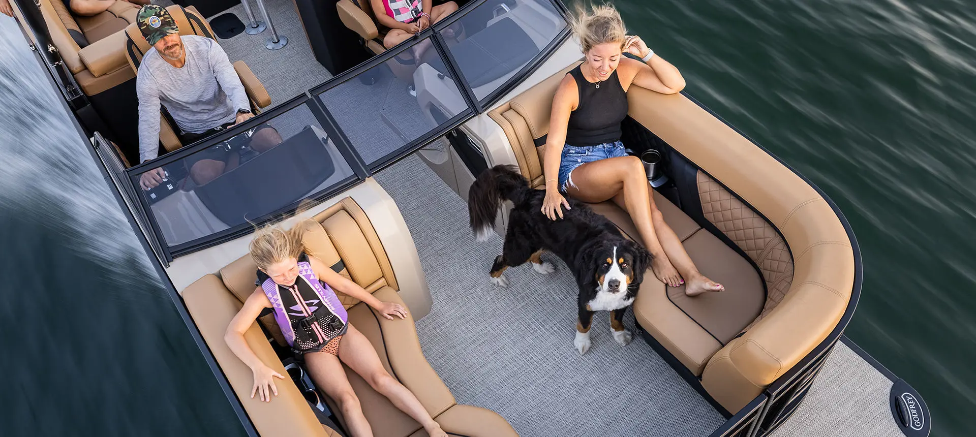 Aerial view of a family relaxing on a Godfrey AquaPatio Lounge pontoon boat.