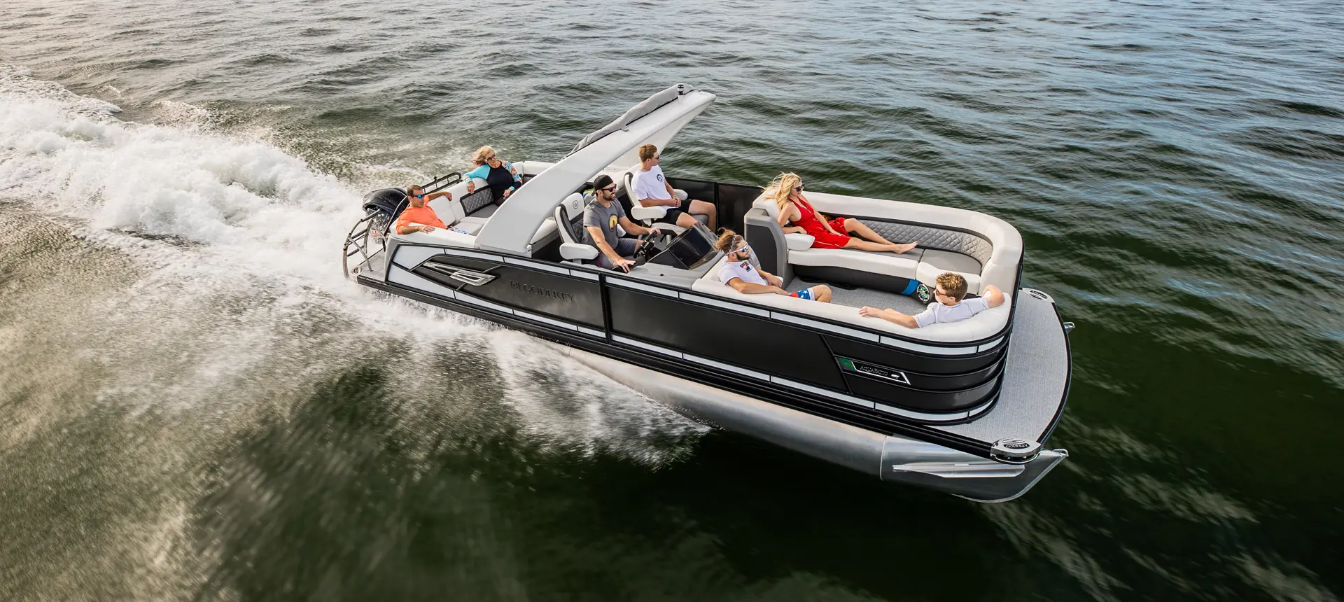 Family cruising the lake on their Godfrey AquaPatio Lounge pontoon boat.