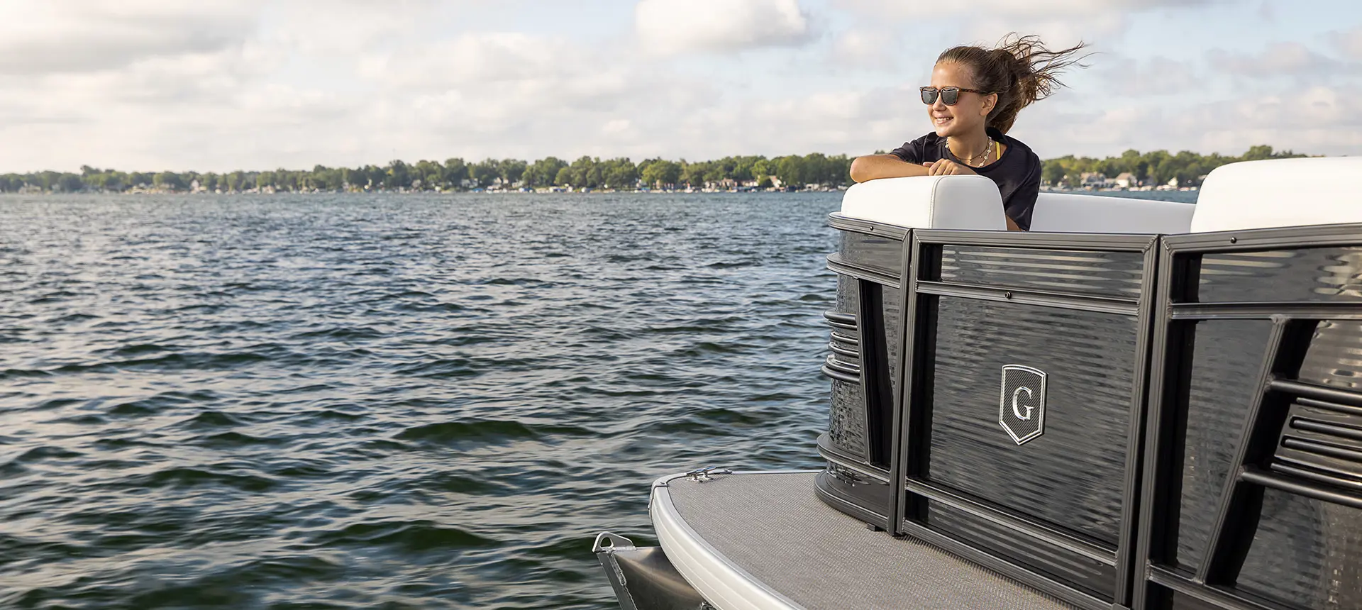 girl sitting on the bow split bench seat on a godfrey aquapatio split bench pontoon