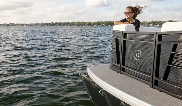 girl sitting on the bow split bench seat on a godfrey aquapatio split bench pontoon