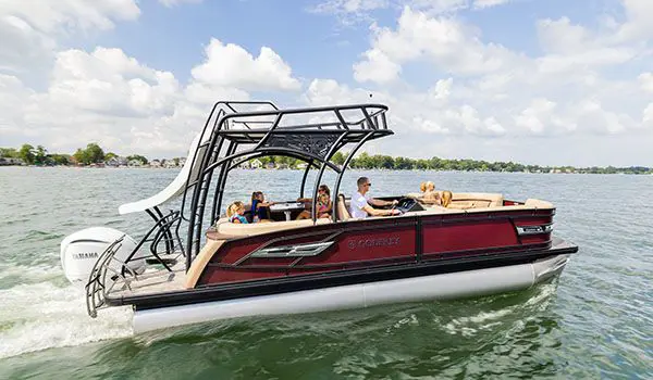 side view of a godfrey aquapatio sundeck pontoon cruising on a lake