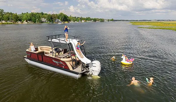 kids using the slide on a godfrey aquapatio sundeck pontoon and swimming around it