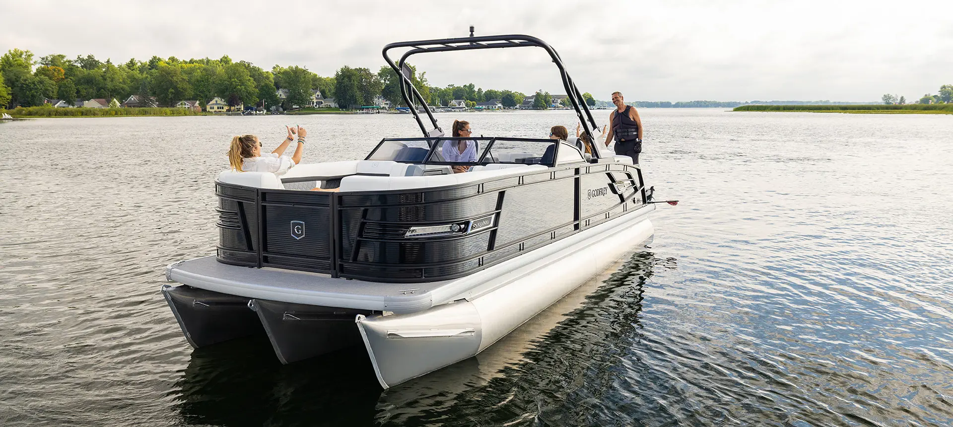 girl giving thumbs up to her dad on a godfrey aquapatio winshield pontoon