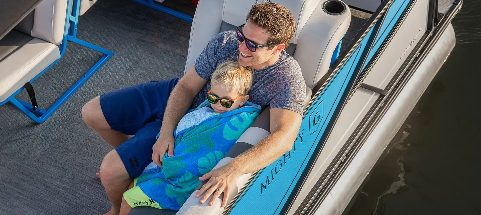 Father and son relaxing on a Godfrey Mighty G Cruise pontoon boat.