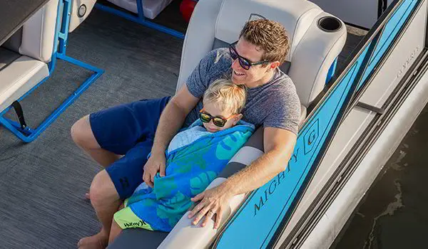 père et fils se détendant sur un ponton godfrey mighty g cruise
