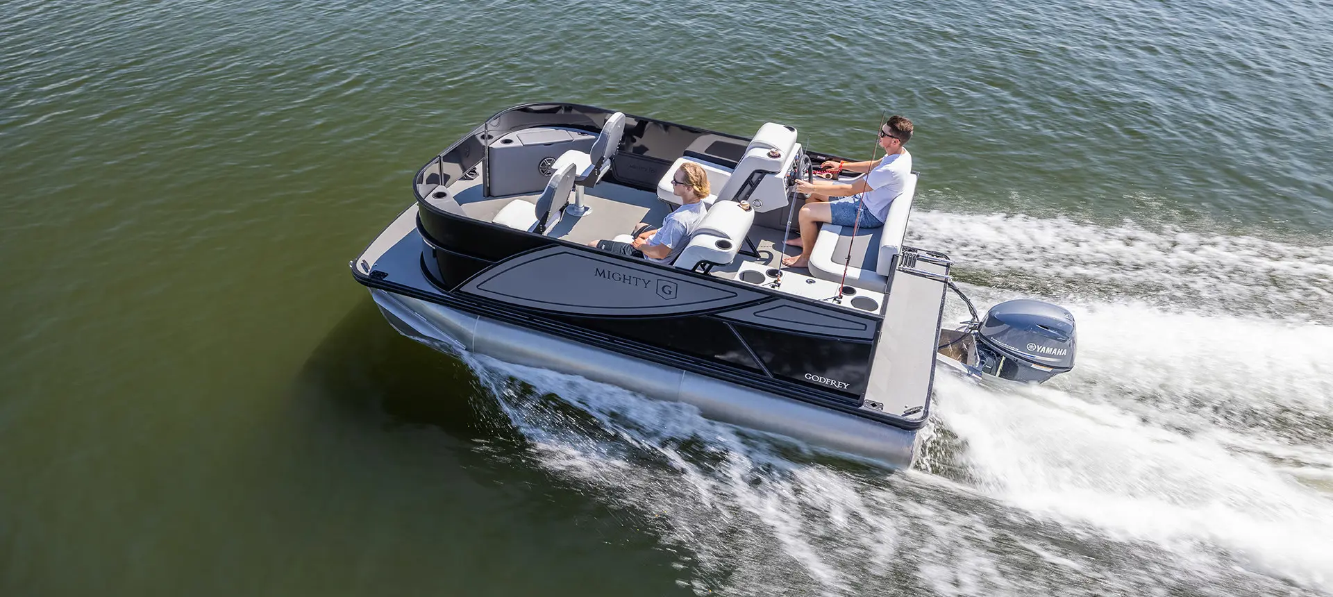 Aerial view of 2 guys cruising to their fishing spot on a Godfrey Mighty G Fishing pontoon boat.