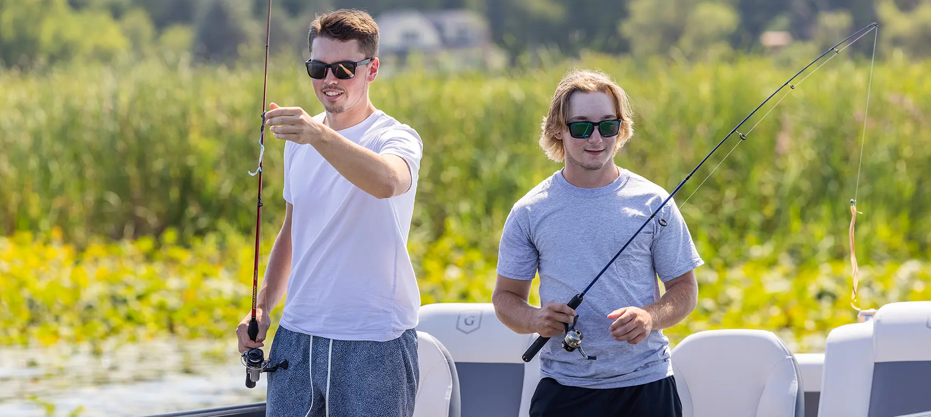 2 guys getting ready to cast their lines out on a Godfrey Mighty G Fishing pontoon boat.