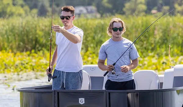 2 guys getting ready to cast their lines out on a Godfrey Mighty G Fishing pontoon boat.