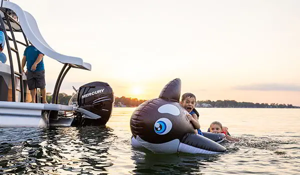 kids swimming near the stern of a godfrey monaco sundeck pontoon