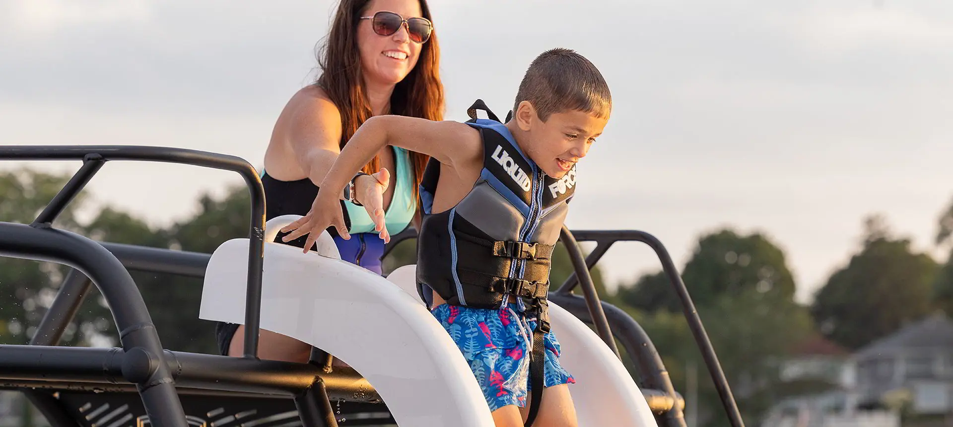 mom helping son down the slide on a godfrey monaco sundeck pontoon