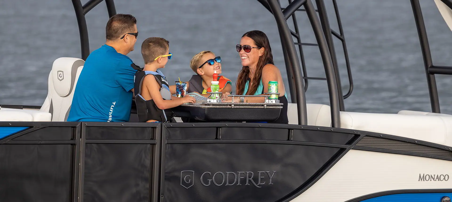 family eating at the midship table on a godfrey monaco sundeck pontoon