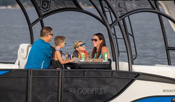 family eating at the midship table on a godfrey monaco sundeck pontoon