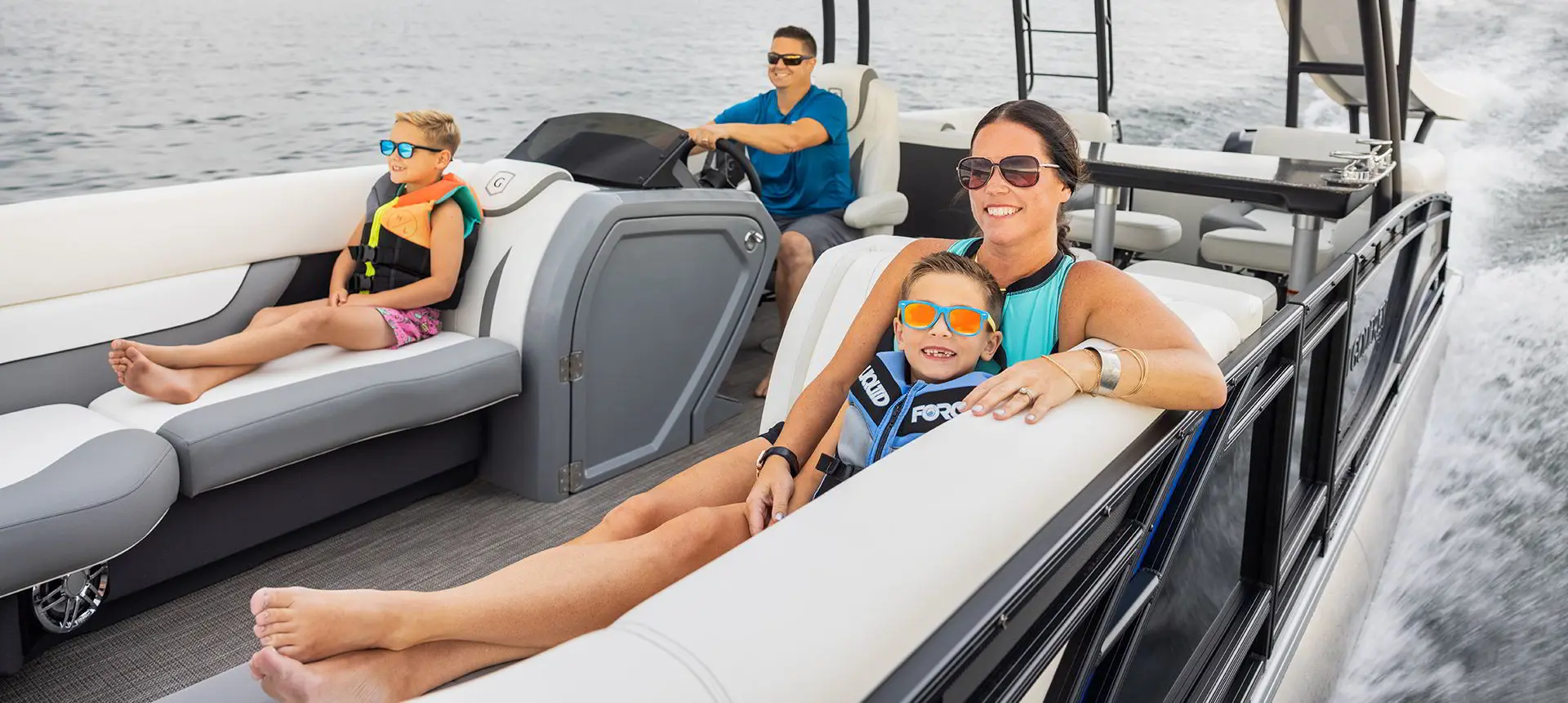 mother and son relaxing on the split bench seats on a godfrey monaco sundeck pontoon