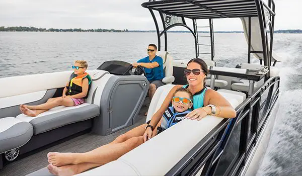 mother and son relaxing on the split bench seats on a godfrey monaco sundeck pontoon