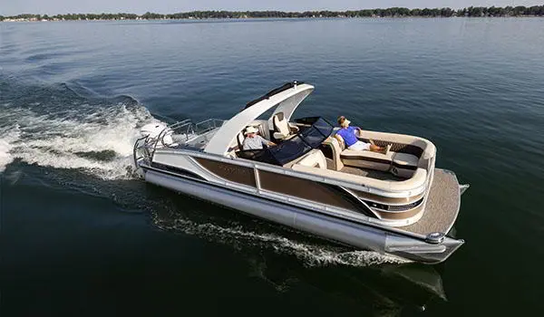 side view of a godfrey sanpan lounge pontoon cruising on a lake
