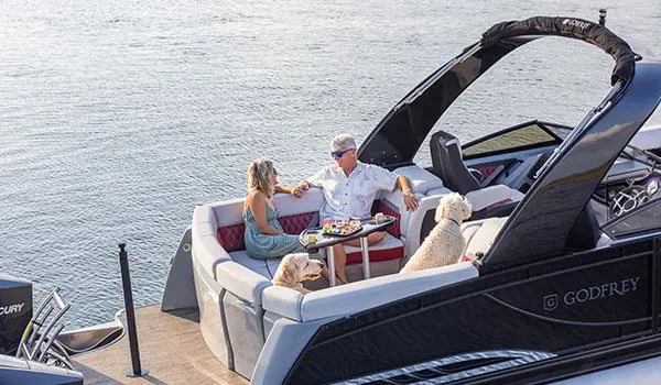 couple relaxing on the stern ultra lounge on a godfrey sanpan lounge pontoon