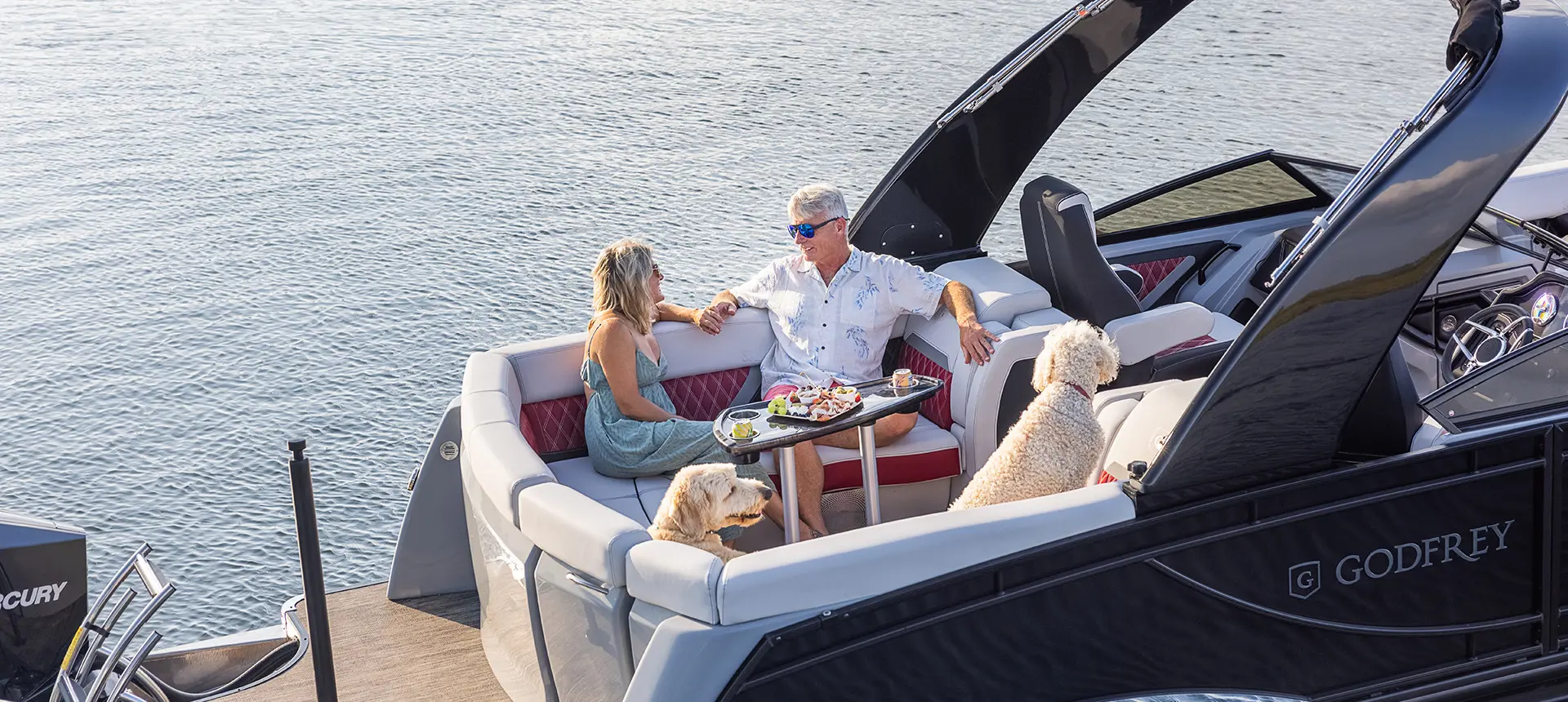 couple se détendant sur la chaise longue en poupe du ponton godfrey sanpan lounge