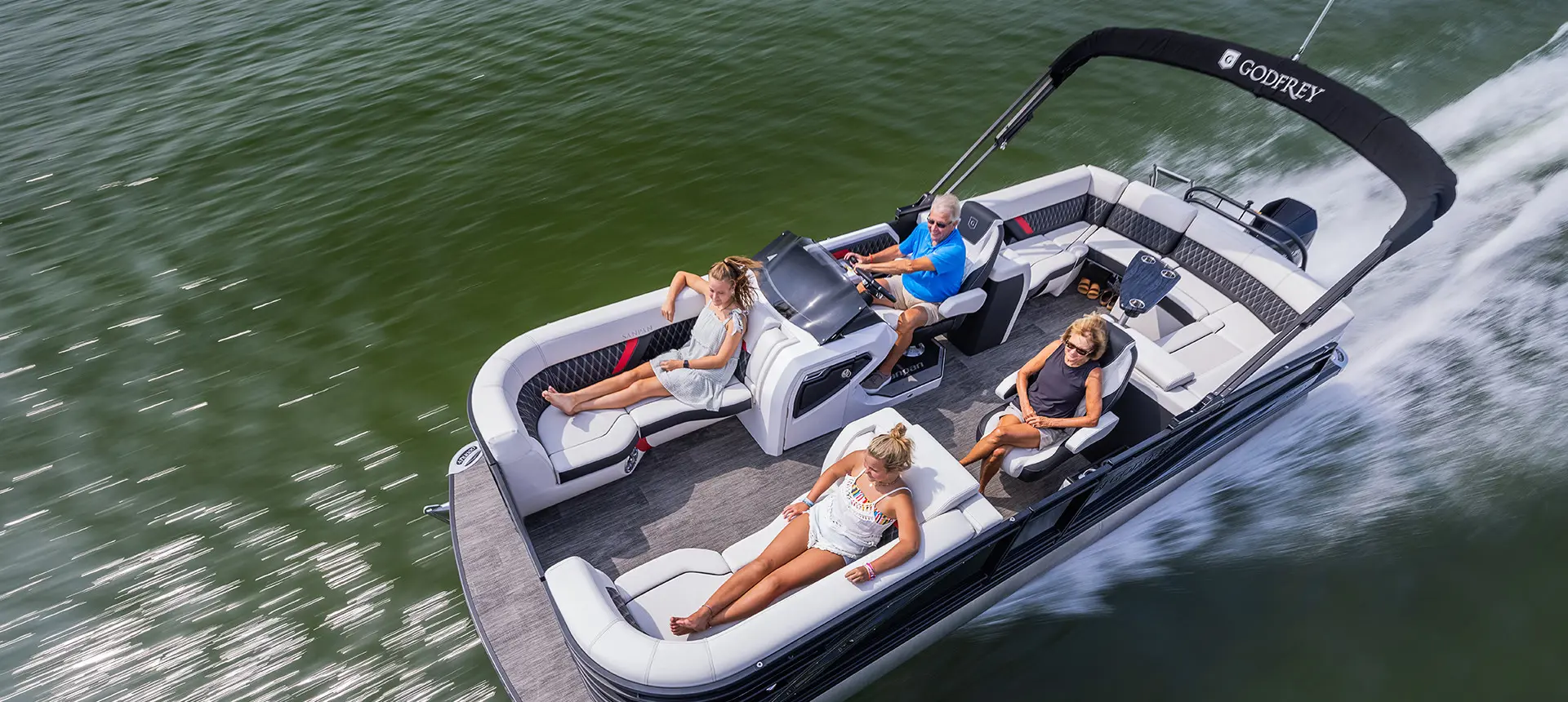 aerial view of a family cruising a lake with their godfrey sanpan lounge pontoon