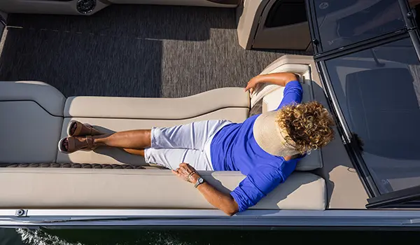 woman relaxing on the premium seating on a godfrey sanpan lounge pontoon