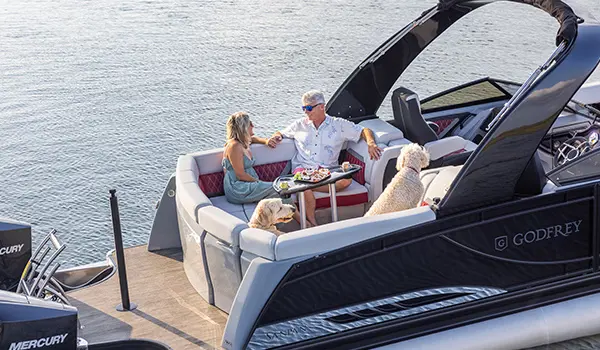 couple se détendant sur la chaise longue en poupe du ponton godfrey sanpan lounge