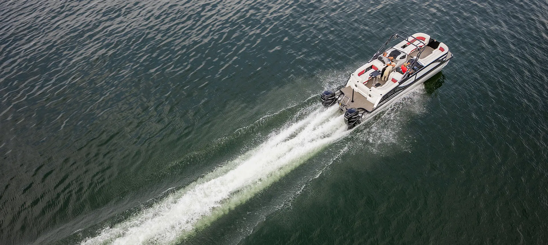 Godfrey Sanpan Twin tritoon speeding across a lake.