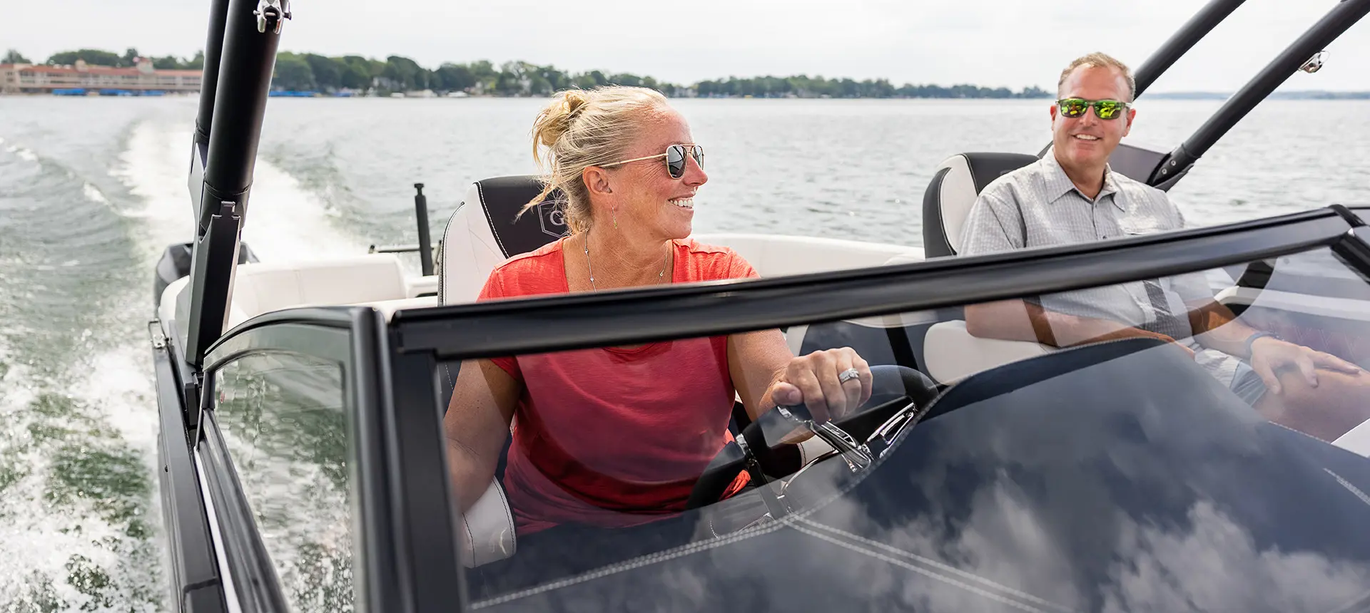 Femme à la barre pilotant un ponton Godfrey Sanpan Windshield.