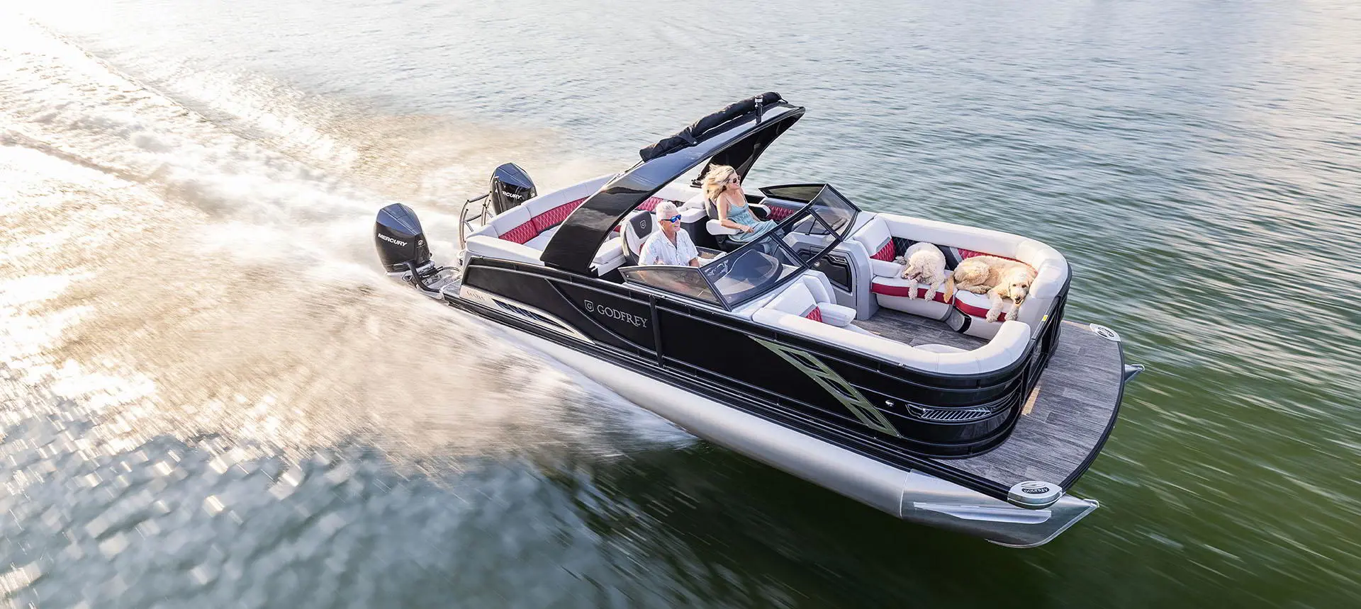 Ponton Godfrey Sanpan Windshield traversant un lac à toute vitesse.