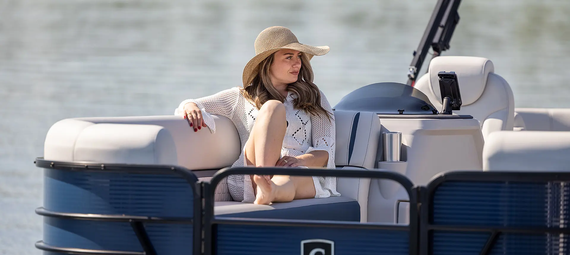 femme assise sur la banquette divisée en proue regardant le lac sur un ponton godfrey sweetwater split bench