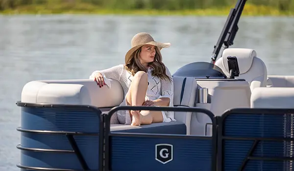 femme assise sur la banquette divisée en proue regardant le lac sur un ponton godfrey sweetwater split bench