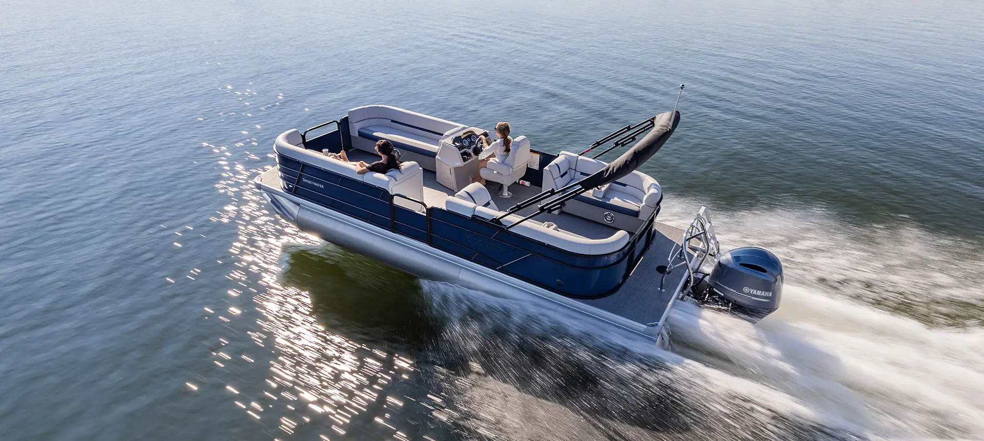 vue latérale d’un ponton godfrey sweetwater split bench naviguant sur un lac