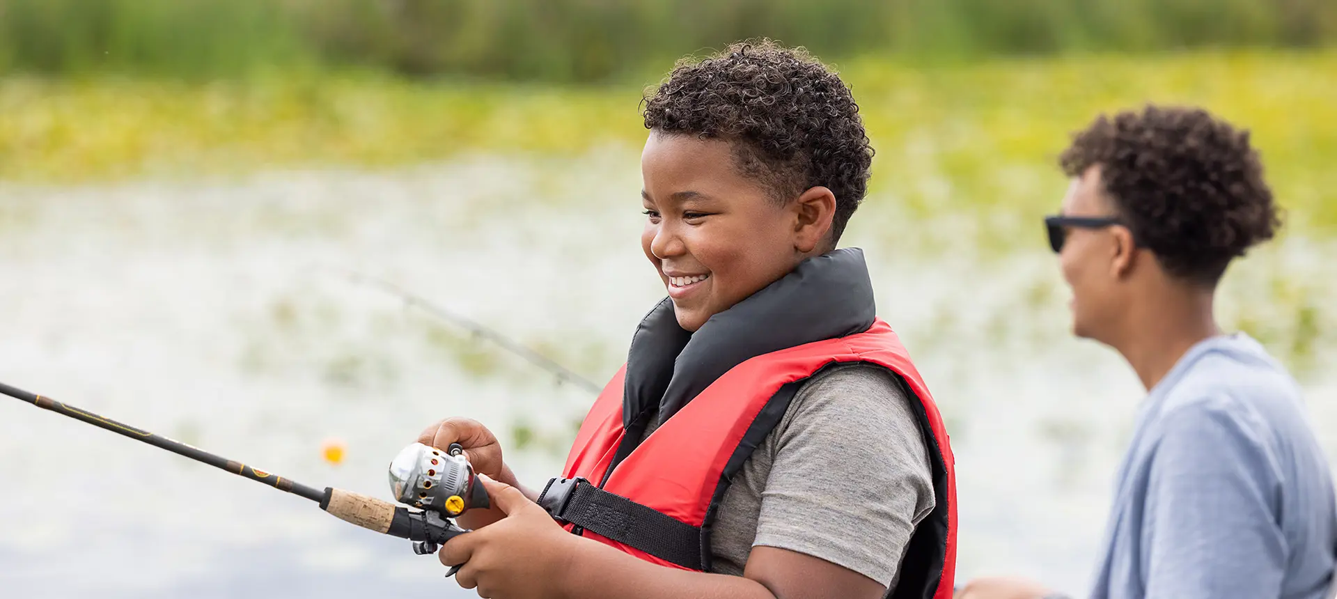 garçons souriants qui pêchent sur un ponton godfrey xperience fishing