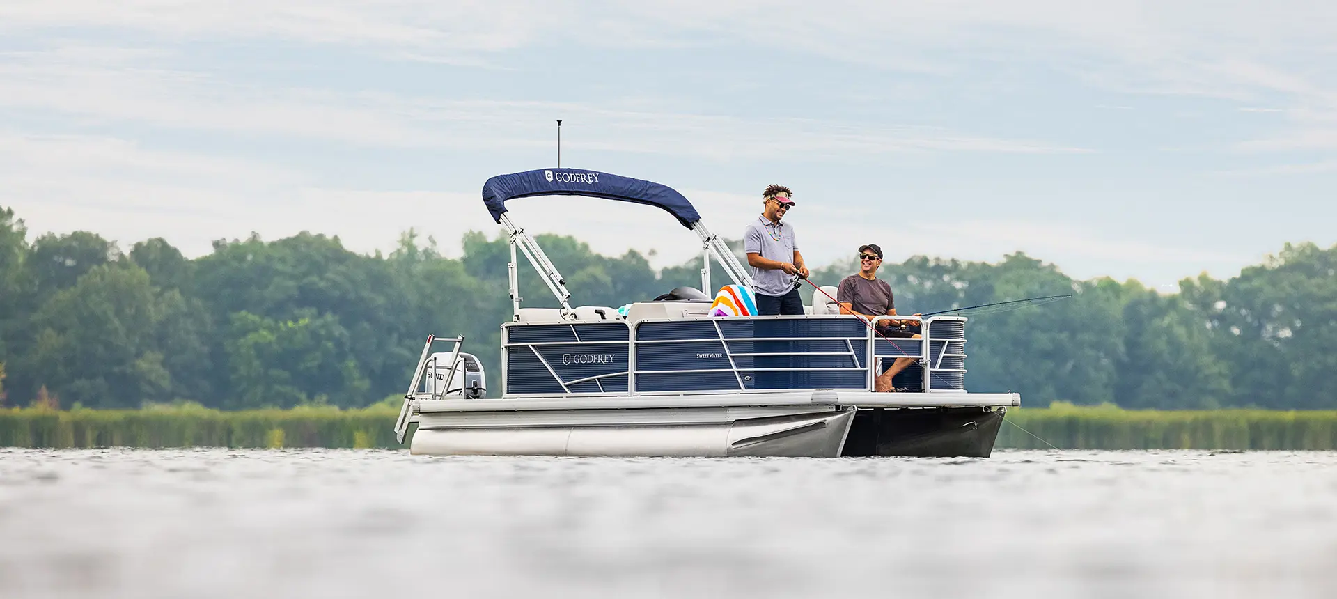 deux hommes pêchent à la proue d’un ponton godfrey xperience fishing