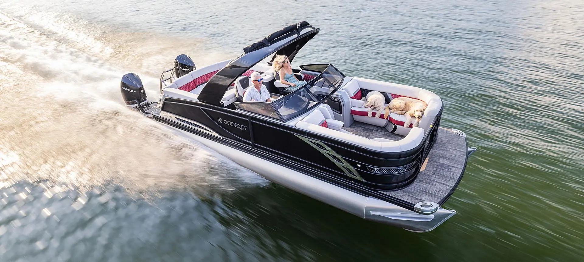 Ponton Godfrey Sanpan Lounge 2700 ULW Twin traversant à toute vitesse un lac.