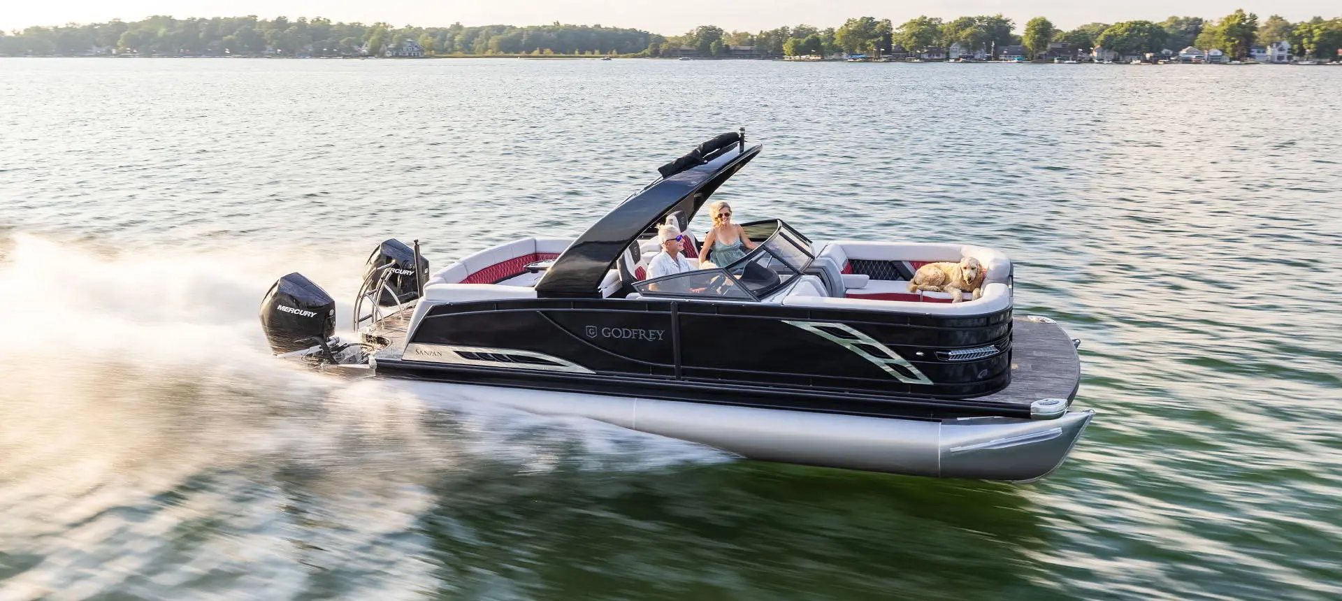 Profil latéral d’un ponton Godfrey Sanpan Lounge 2700 ULW Twin naviguant à toute vitesse sur un lac.