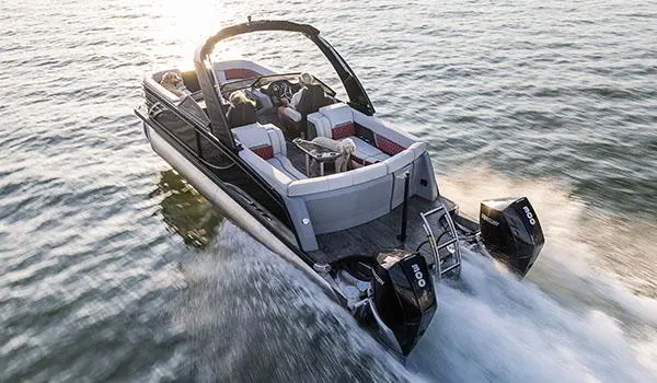 Vue de la poupe d’un ponton Godfrey Sanpan Lounge 2700 ULW Twin traversant un lac à toute vitesse.