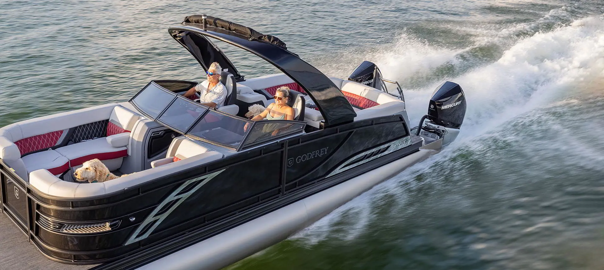 Vue latérale d’un couple profitant d’une journée au lac sur un ponton Godfrey Sanpan Lounge 2700 ULW Twin.