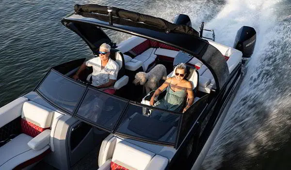 Couple avec leurs chiens souriant dans un bateau ponton Godfrey Sanpan Lounge 2700 ULW Twin.