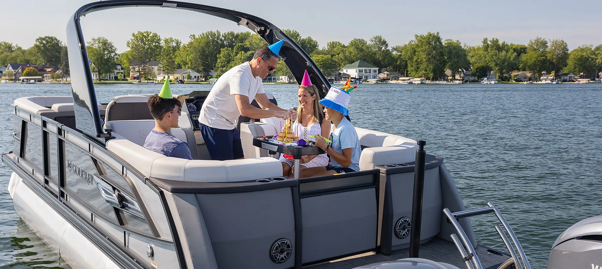 family having a birthday party at the table on a godfrey aquapatio series pontoon