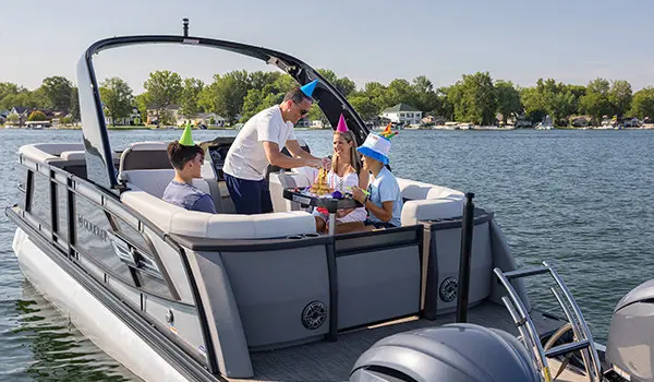 family having a birthday party at the table on a godfrey aquapatio series pontoon