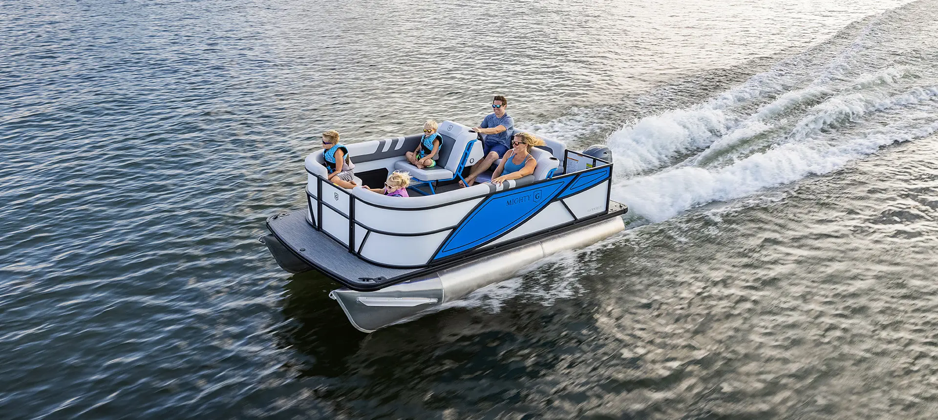 family cruising a lake on their godfrey mighty g cruise pontoon