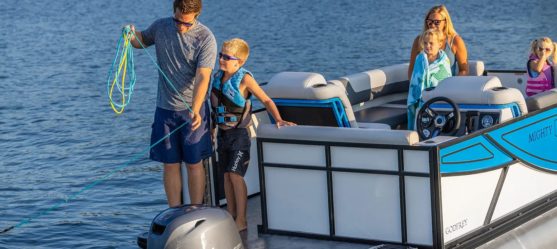 father and son throwing out the anchor on their godfrey mighty g cruise pontoon