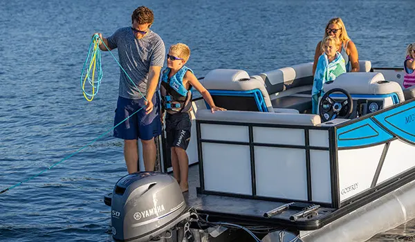 father and son throwing out the anchor on their godfrey mighty g cruise pontoon