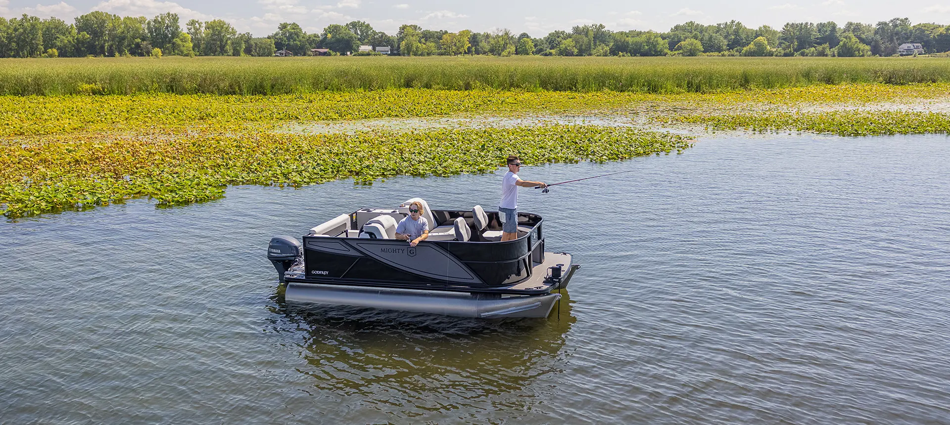 aerial-side view of 2 men fishing on their godfrey mighty g fishing pontoon