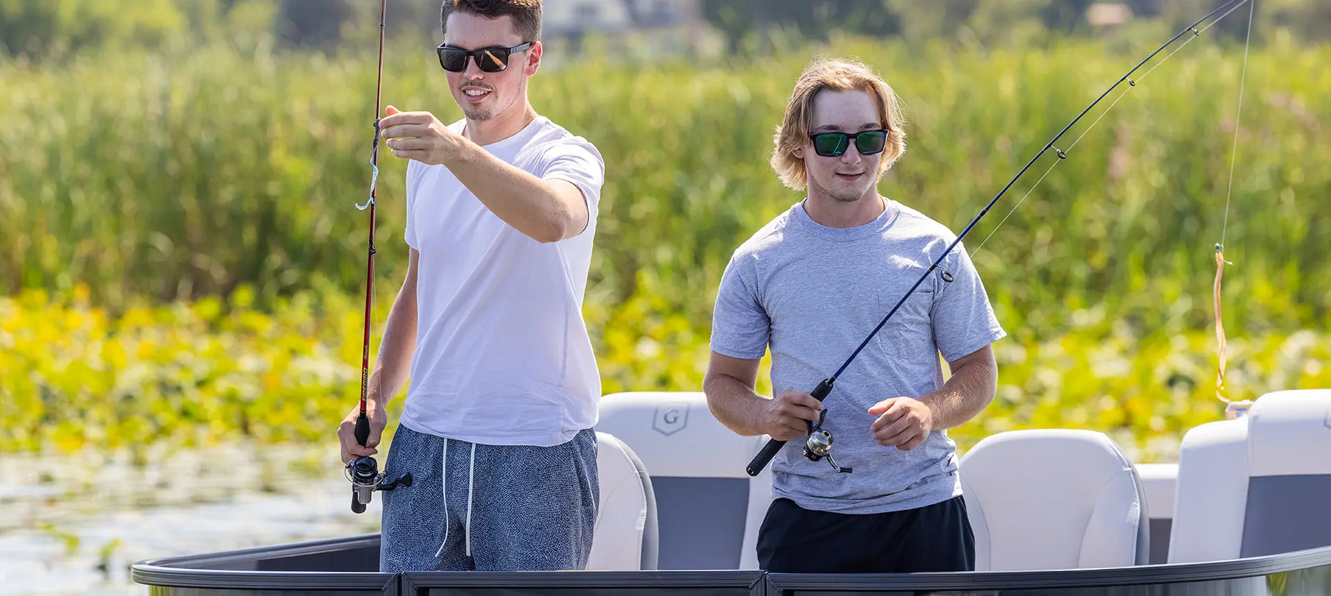 2 young men about to cast their fishing lines from a godfrey mighty g fishing pontoon