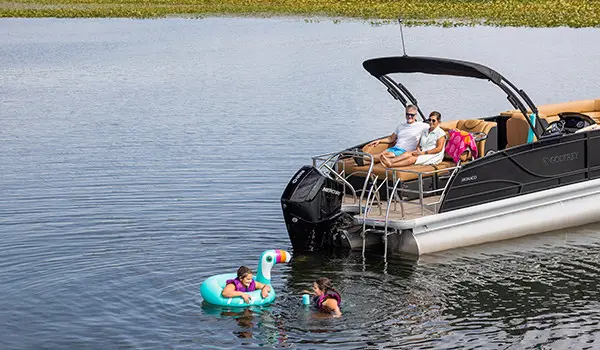parents watching their kids swimming near their godfrey monaco series pontoon