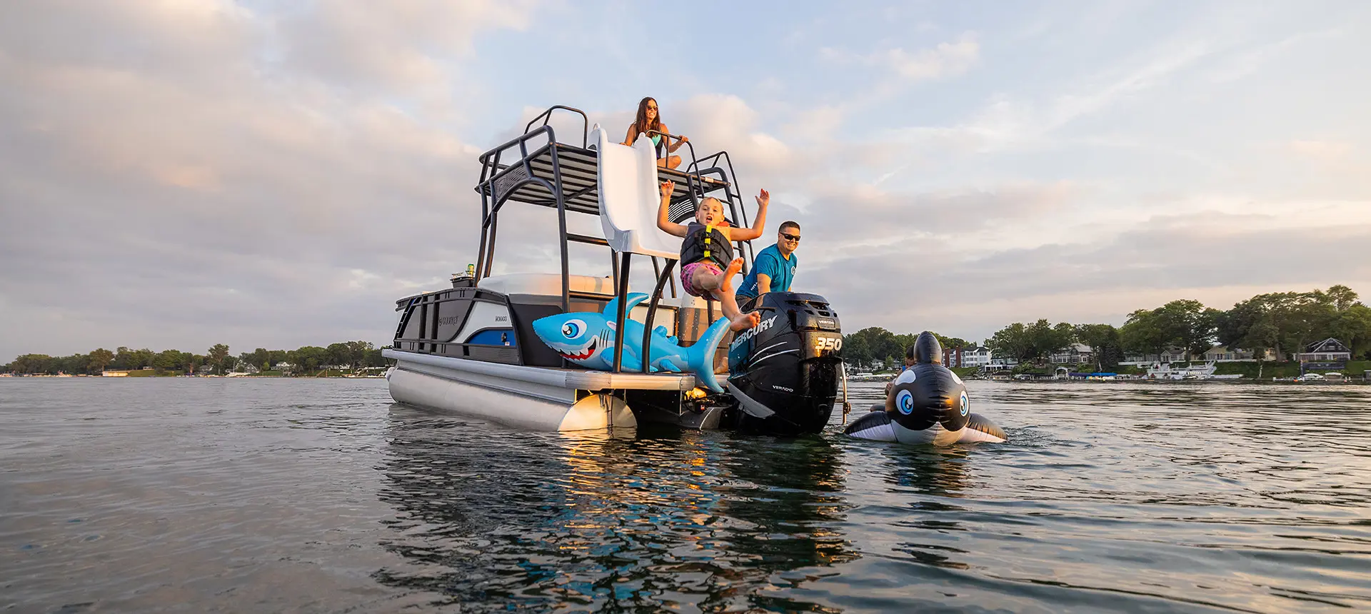 kids going off the sundeck slide on a godfrey monaco series pontoon
