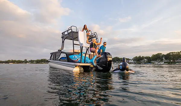 kids going off the sundeck slide on a godfrey monaco series pontoon