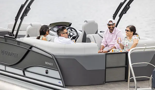 friends relaxing on the stern split bench seats on a godfrey monaco series pontoon