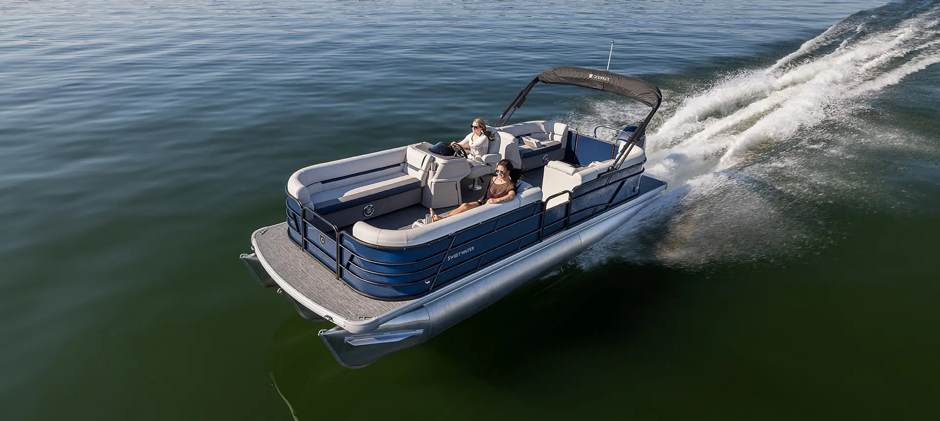 2 women cruising on a lake in a godfrey sweetwater tritoon