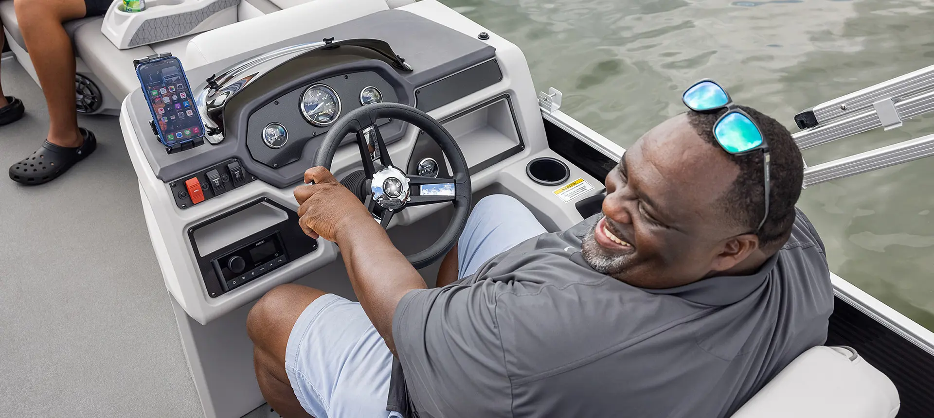 man sitting at the helm on a godfrey xperience pontoon